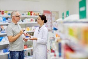 pharmacist and senior man buying drug at pharmacy