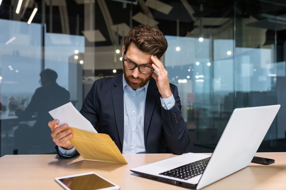 Man reads letter informing him that his architectural license is under scrutiny