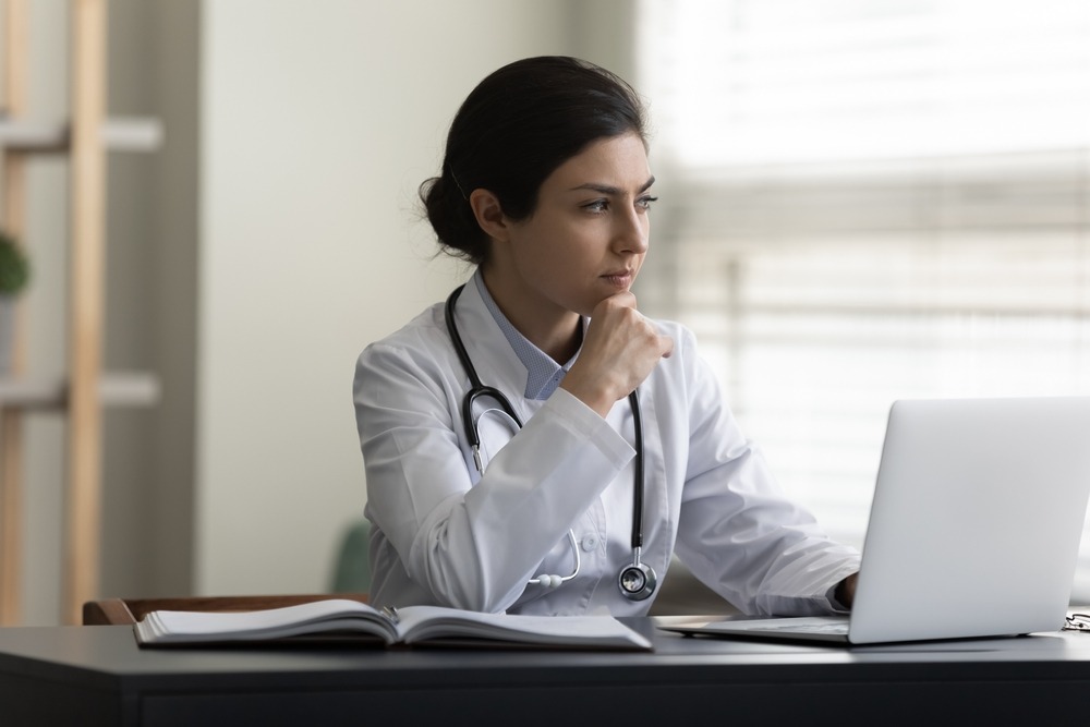 A Texas physician assistant sits at a desk thinking about medical license defense.